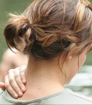 Woman holding her neck because she has neck pain due to a whiplash injury in a car accident