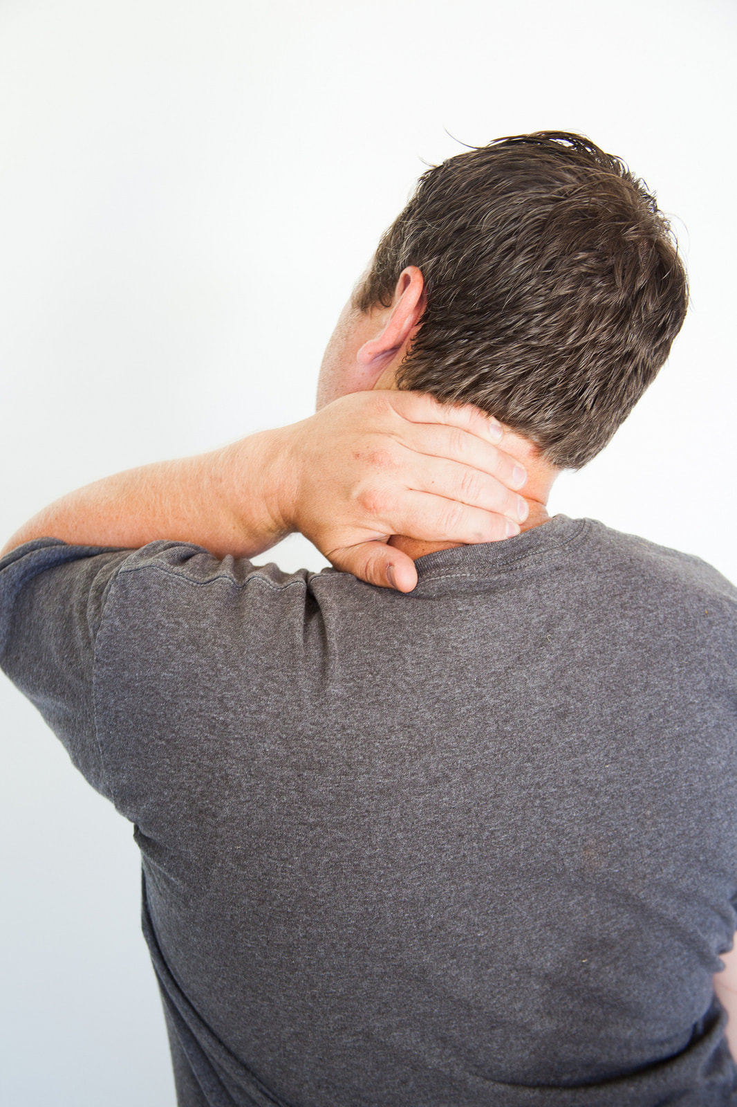 Man holding his neck because he has neck and back pain